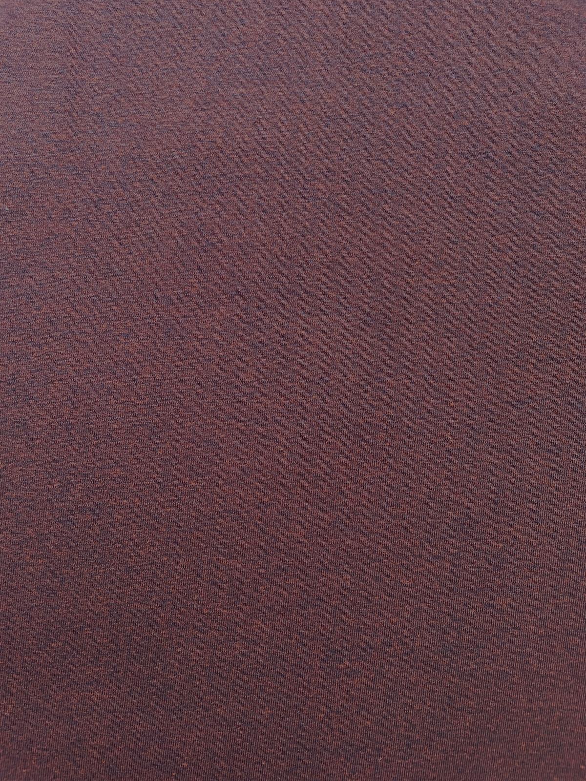 Elegantes Wickelkleid aus kastanienbraunem Jersey auf einer Schneiderpuppe in einer Nähatelier-Umgebung.