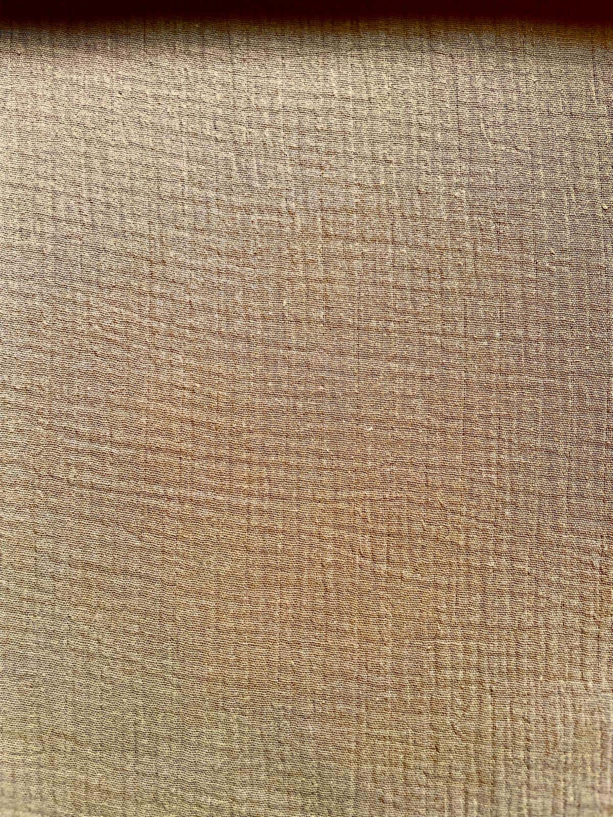 Weicher Musselin-Stoff als Meterware in Beige mit der typisch gekreppten, luftigen Struktur in der Nahaufnahme.