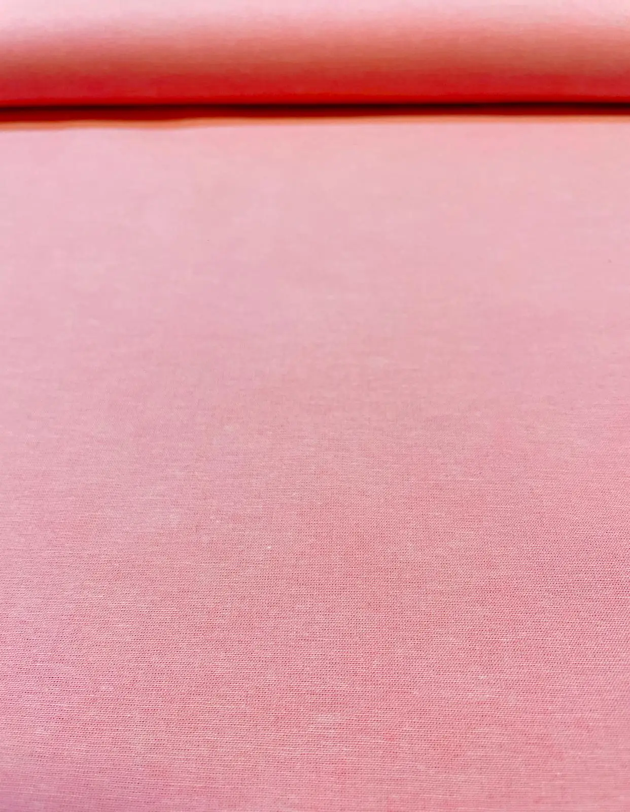Nahaufnahme von feinem, unifarbenem Baumwoll-Popeline Stoff in Rosa als Meterware