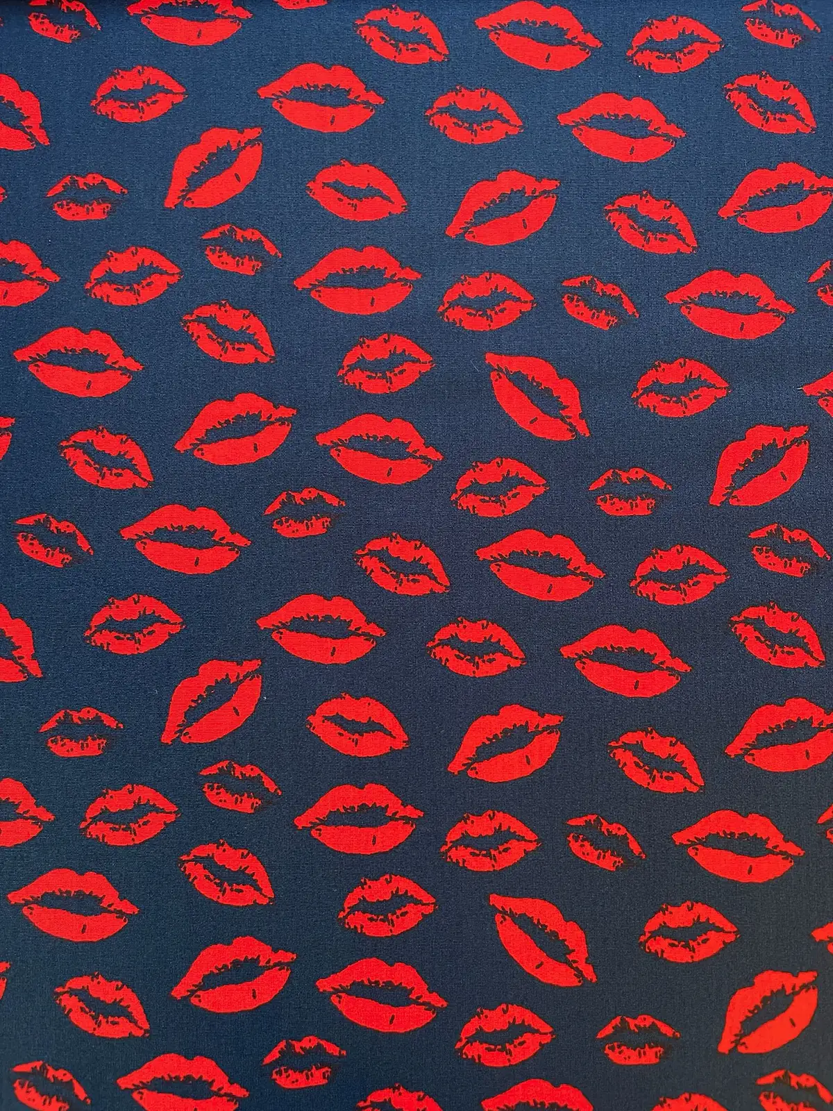 Dunkelblauer Baumwollstoff Popeline mit leuchtend roten Kussmund-Lippen als Allover-Print, 146 cm breit für modische Blusen und Accessoires.