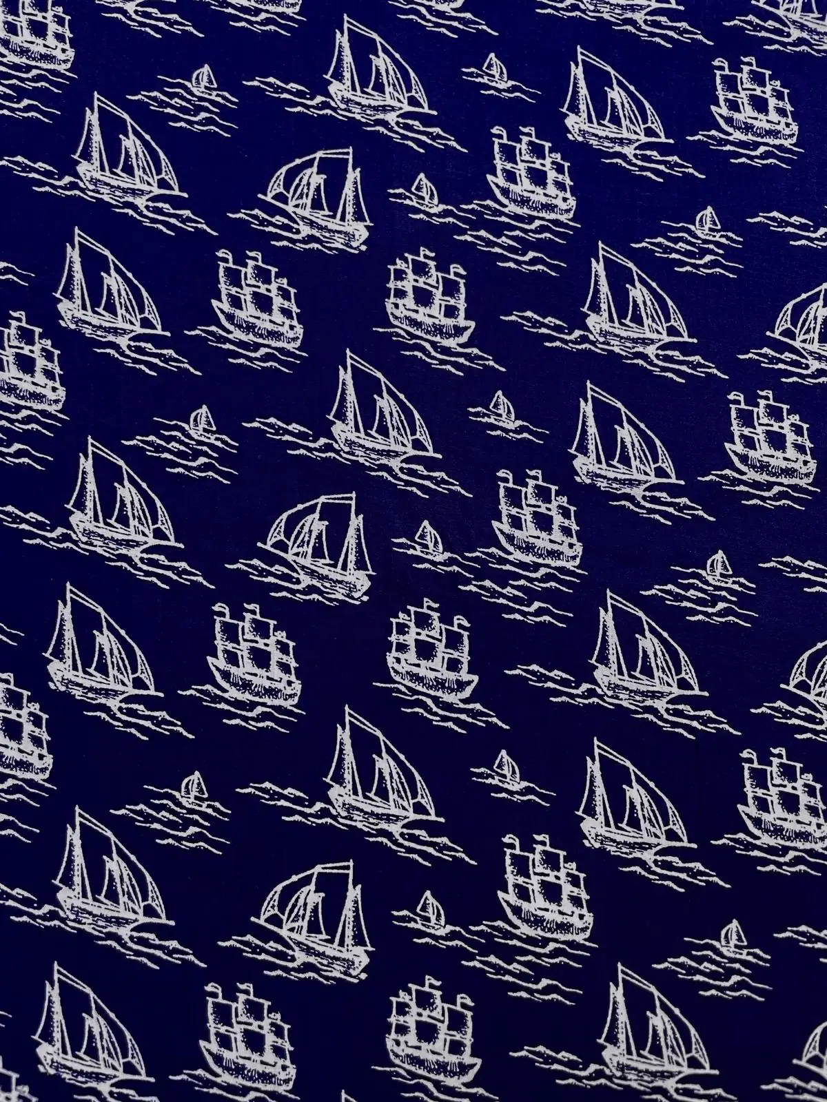 Dunkelblauer Baumwollstoff bedruckt mit weißen Segelschiffen und Segelbooten.