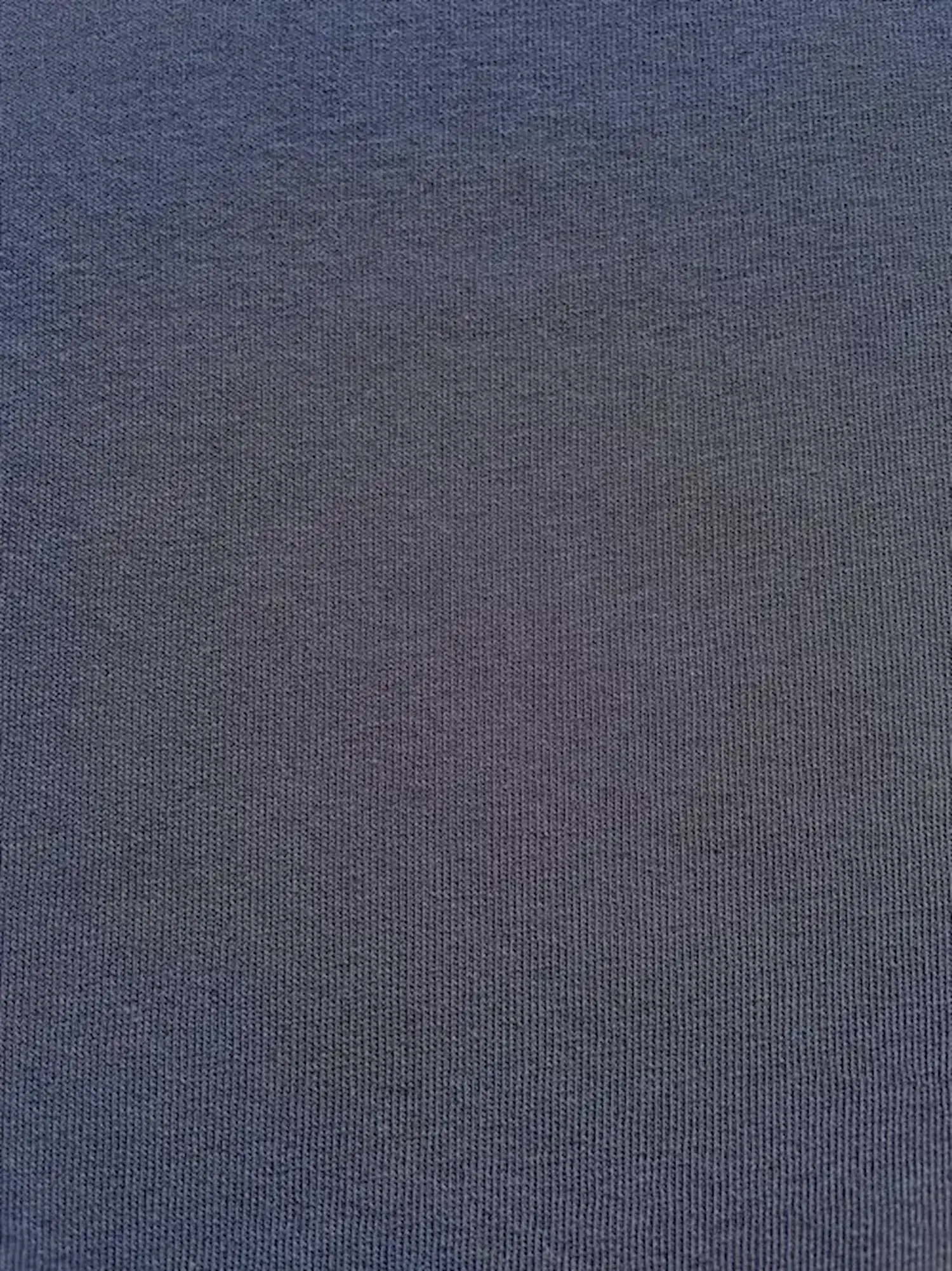 Nahaufnahme der glatten Vorderseite von dunkelblauem Sweatstoff als Meterware mit fein gestrickter Maschenstruktur für Hoodies und Pullover.