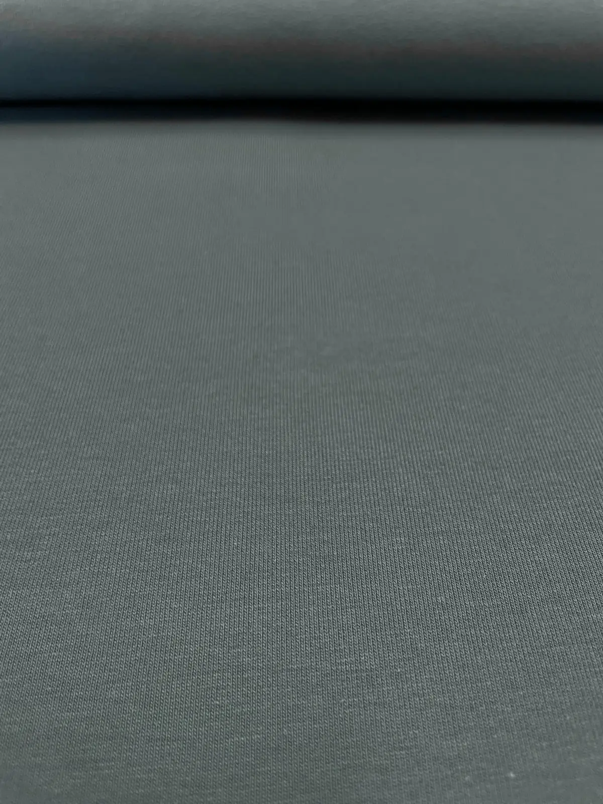 Feine Nahaufnahme von elastischem French Terry Sommersweat in Blaugrau, hochwertige Meterware für Hoodies, Jogginghosen und maritime Nähprojekte.