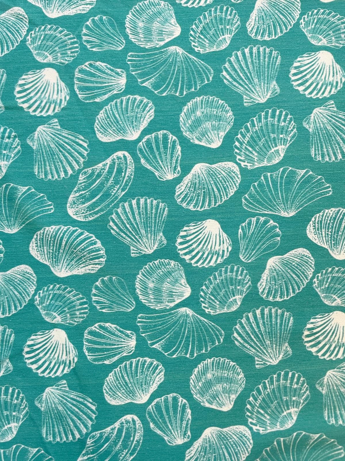 Hochwertiger Jersey-Stoff als Meterware in Petrol-Türkis bedruckt mit feinen weißen Muschel-Motiven im Stoffpfau Onlineshop.