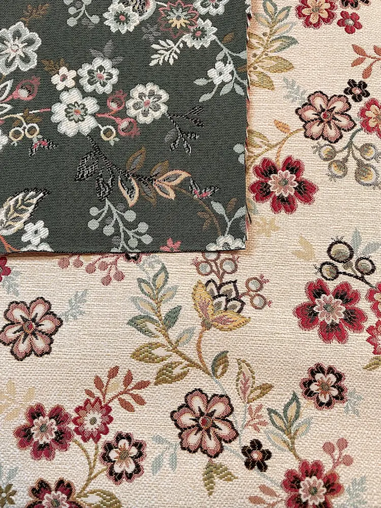 Deko-Gobelinstoff als Meterware mit floralem Jacquard-Muster im direkten Vergleich zwischen der Variante in Beige-Rot und Dunkelgrün mit hellen Blüten.