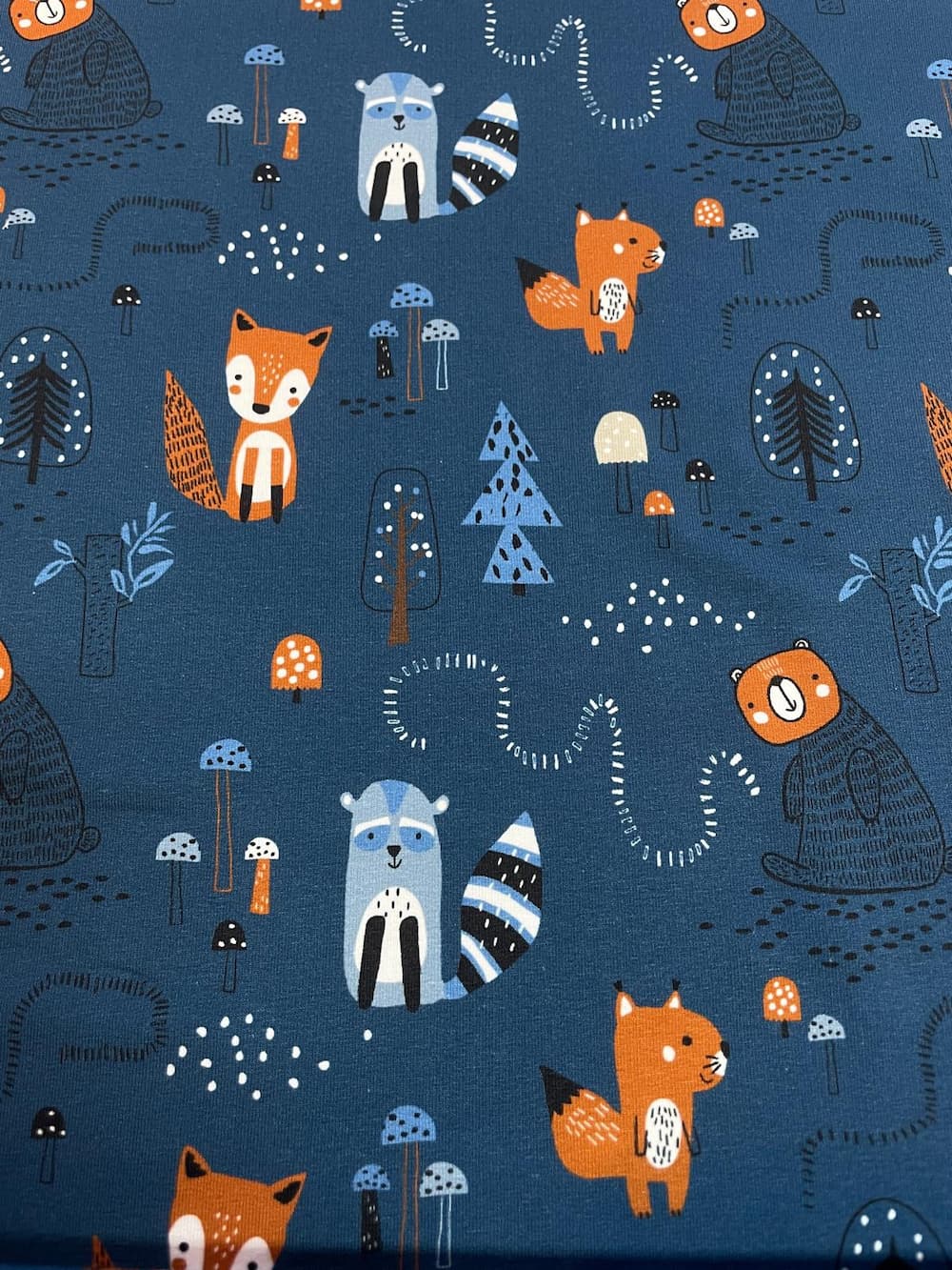 Blauer French Terry Stoff als Meterware mit süßen Waldtier-Motiven wie Fuchs, Waschbär, Bär und Eichhörnchen, ideal für Kinderkleidung.
