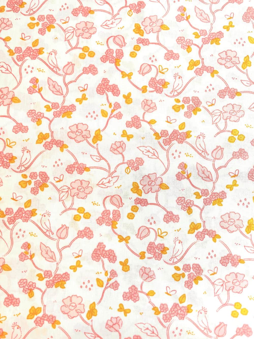 Feiner Baumwollstoff Popeline mit zarten rosa Blumenranken, gelben Schmetterlingen und kleinen Vögeln auf weißem Grund.