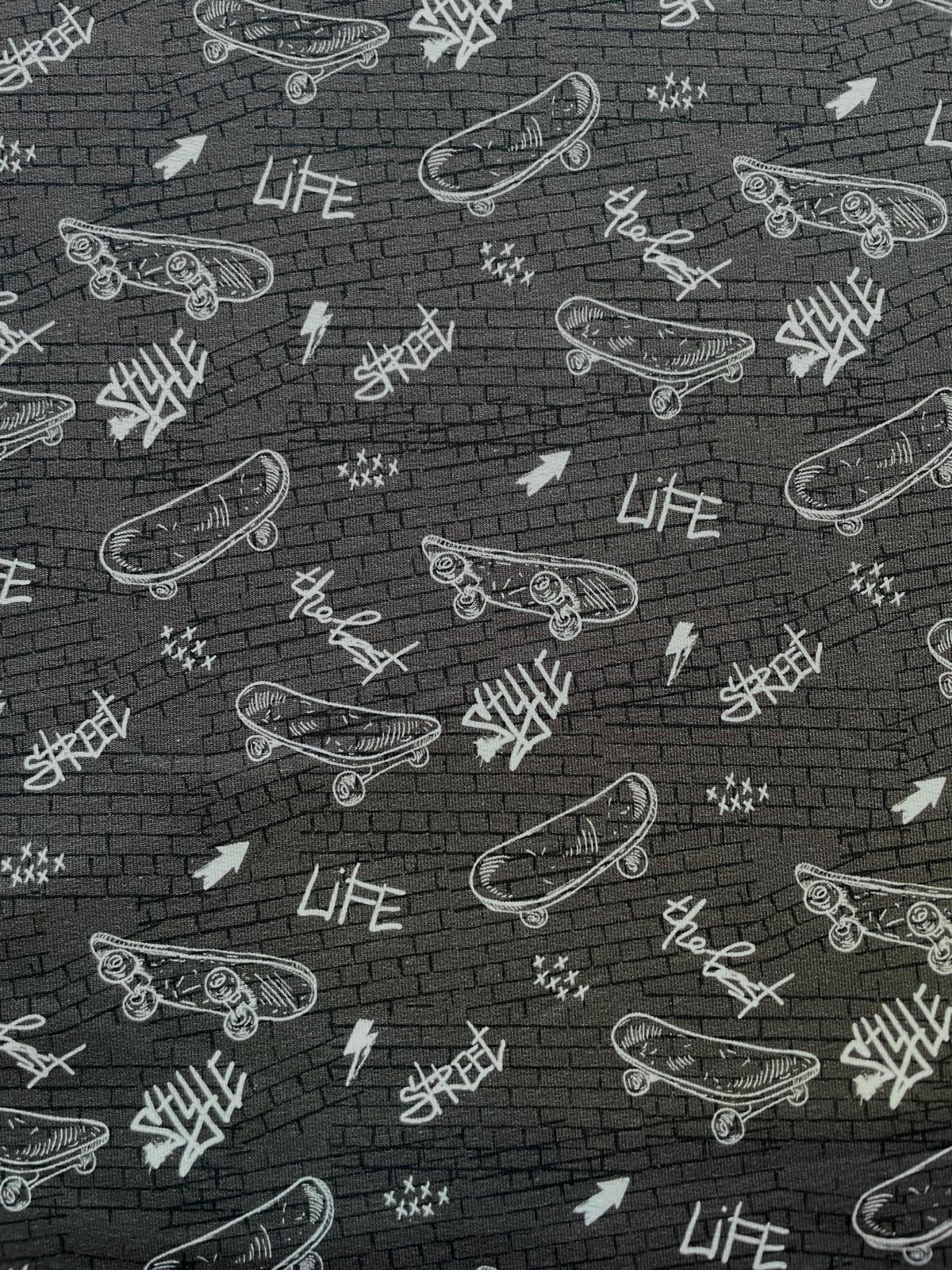 Detailaufnahme French Terry Stoff mit weißen Skateboard-Motiven auf Anthrazit-Melange