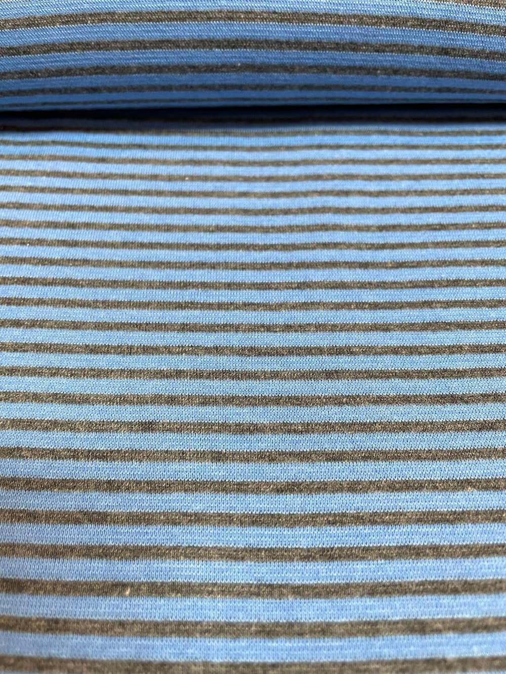 Gestreifter Bündchenstoff in Mittelblau und Dunkelgrau als elastische Schlauchware (Meterware) für Pulloverbündchen und sportliche Streetwear.