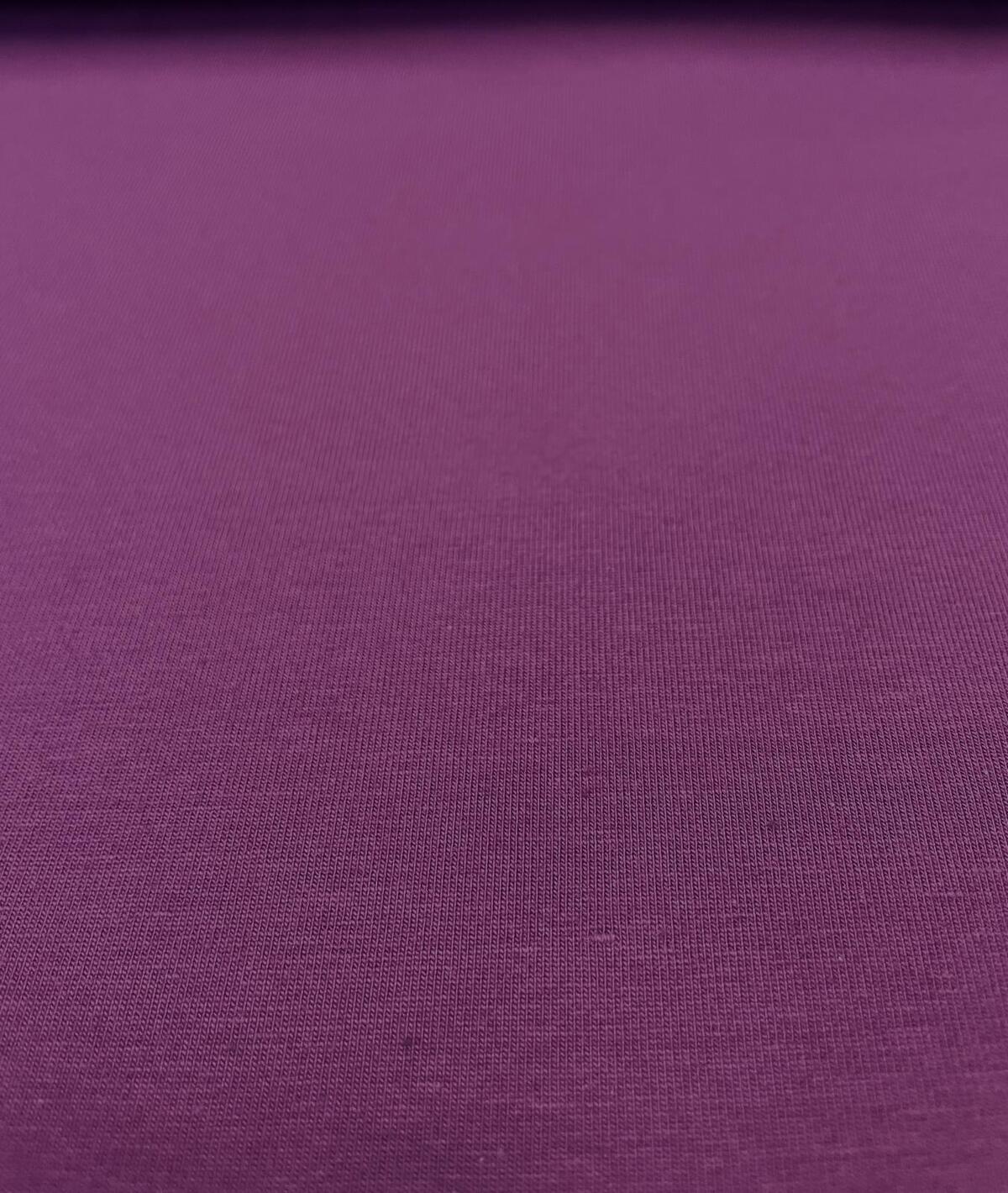 Nahaufnahme eines violetten Baumwoll-Jersey-Stoffes mit feiner Strickstruktur, Farbe Beere, 220g schwere Qualität.