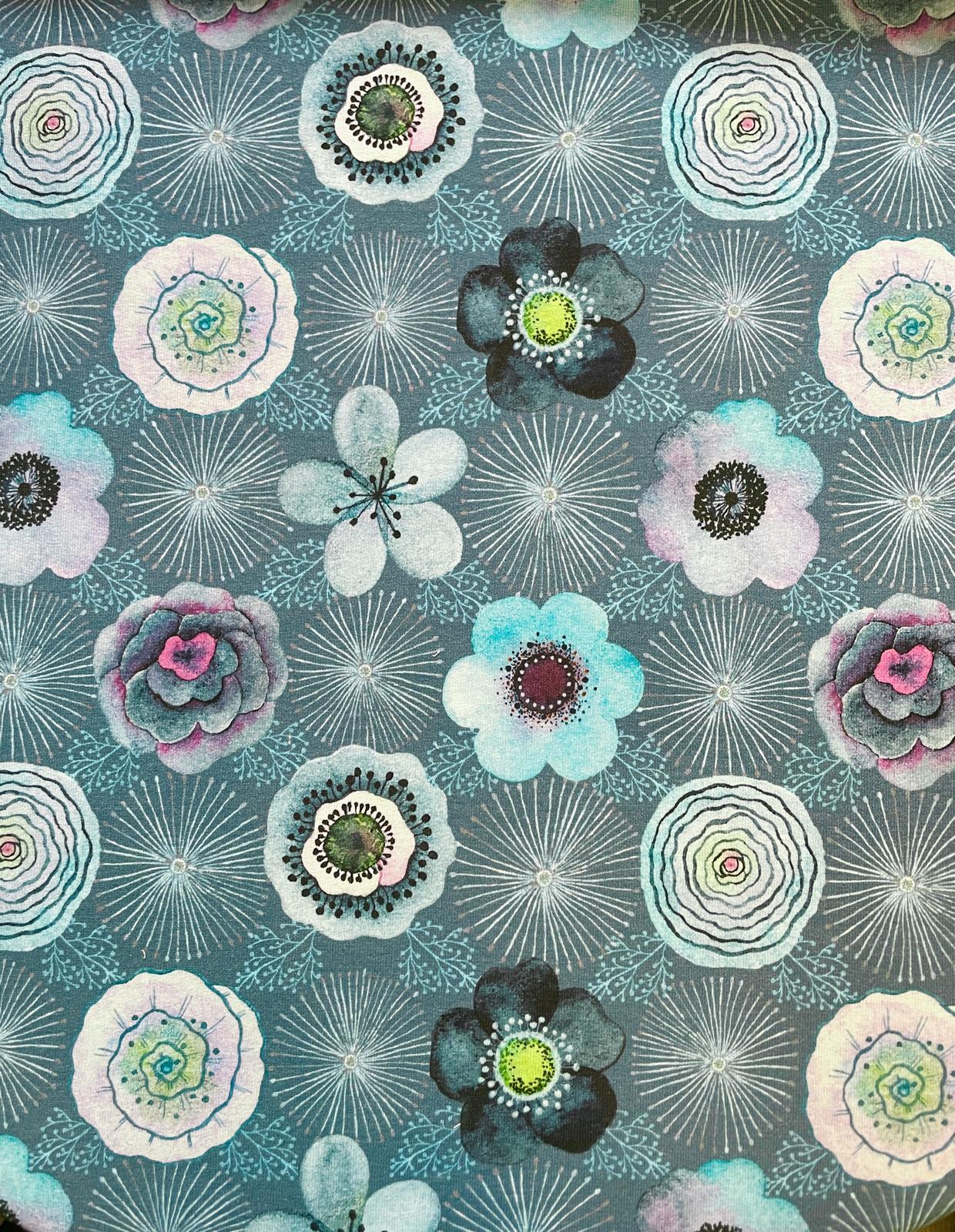 Nahaufnahme von Sommersweat Meterware mit abstrakten Blumenmustern in Türkis, Blau und Violett auf grauem Hintergrund. Hochwertiger Sweatstoff für DIY-Nähprojekte.