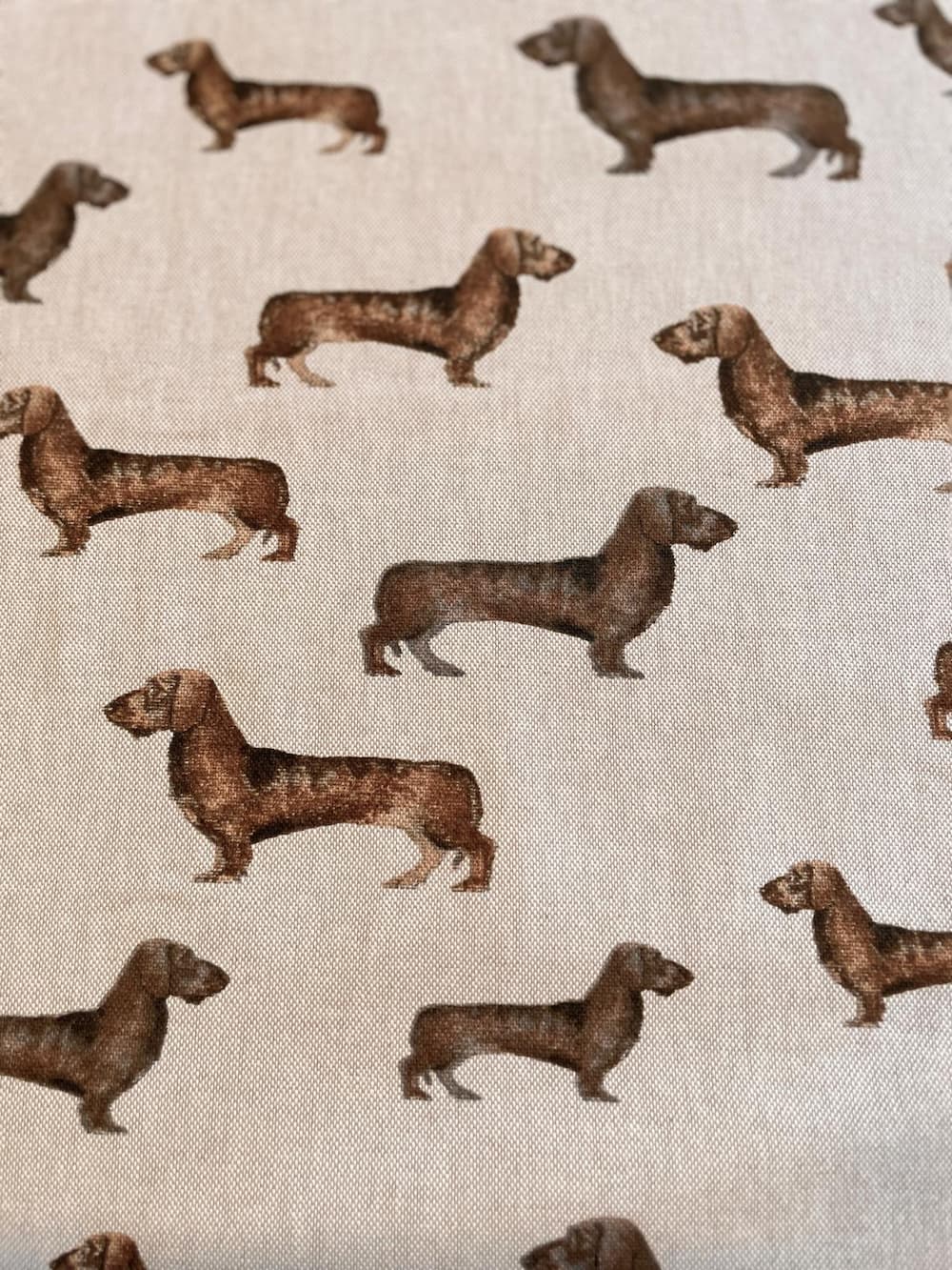 Hochwertiger Deko-Stoff als Meterware in Beige mit detailreichem Dackel-Motiv, ideal für Hundebetten und Kissen.