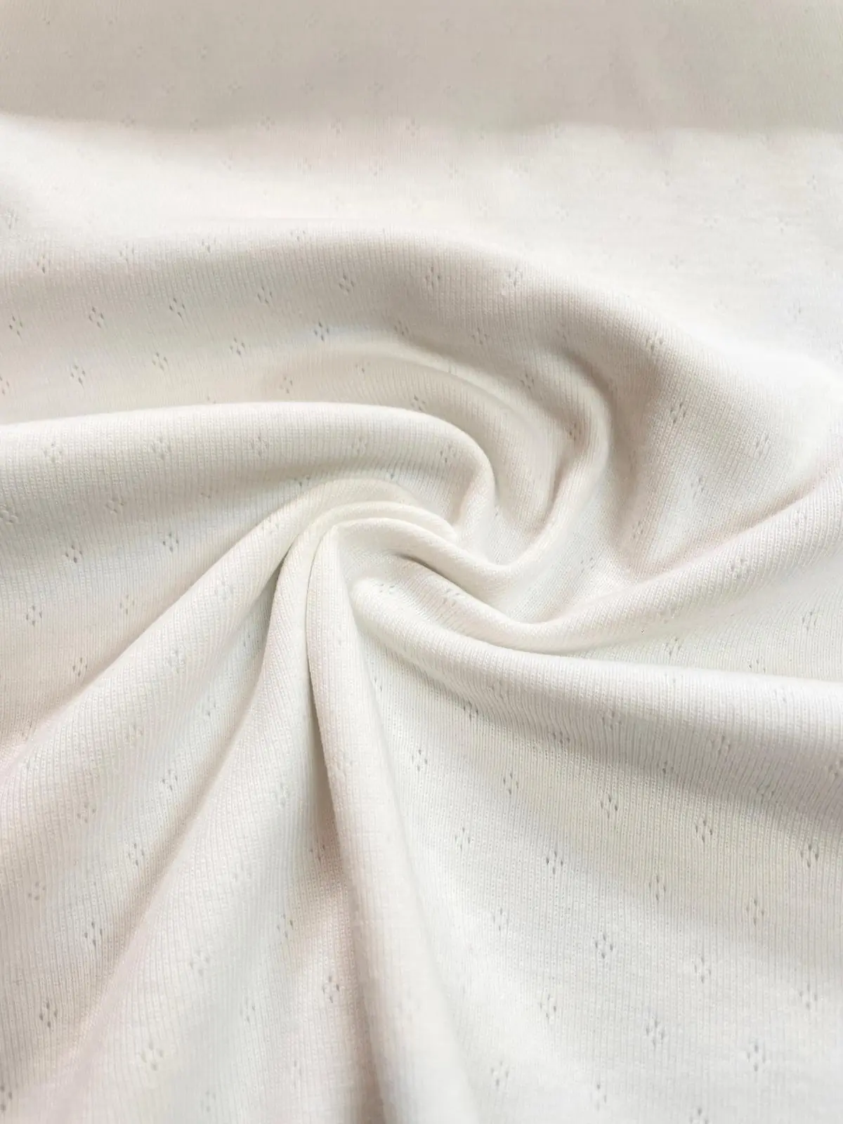 Geraffter Ajour-Jersey in Creme – zarter Feinstrick mit Lochmuster für weich fallende Babykleidung