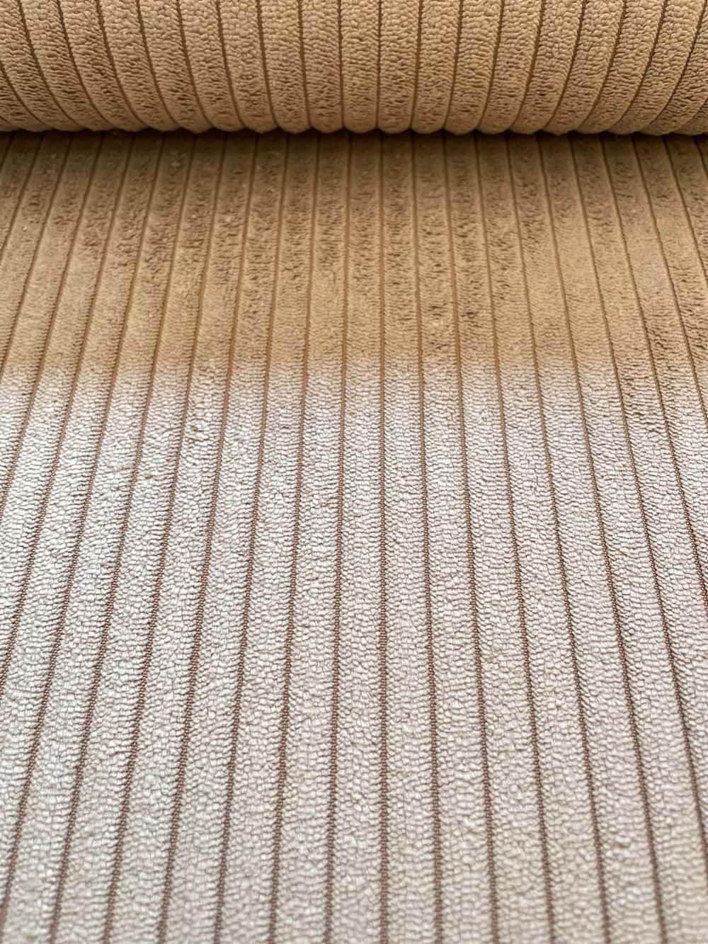 Nahaufnahme eines beigen Breitcord-Stoffs mit charakteristischer Rippenstruktur aus Polyester-Nylon-Mix für Polsterarbeiten und Taschen.