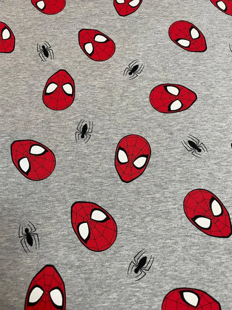 Hochwertiger Baumwoll-Sweat (French Terry) in Grau Meliert mit rotem Spider-Man Masken-Print und schwarzen Spinnen; ideal für Hoodies und Jogginghosen.